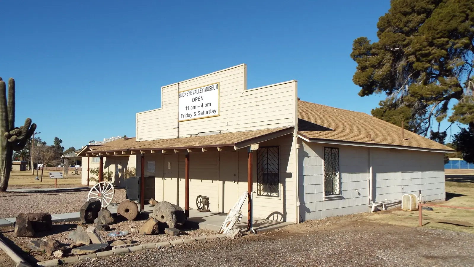 Historic false-front Buckeye Valley Museum in downtown Buckeye, Arizona, with a saguaro and wagon wheels