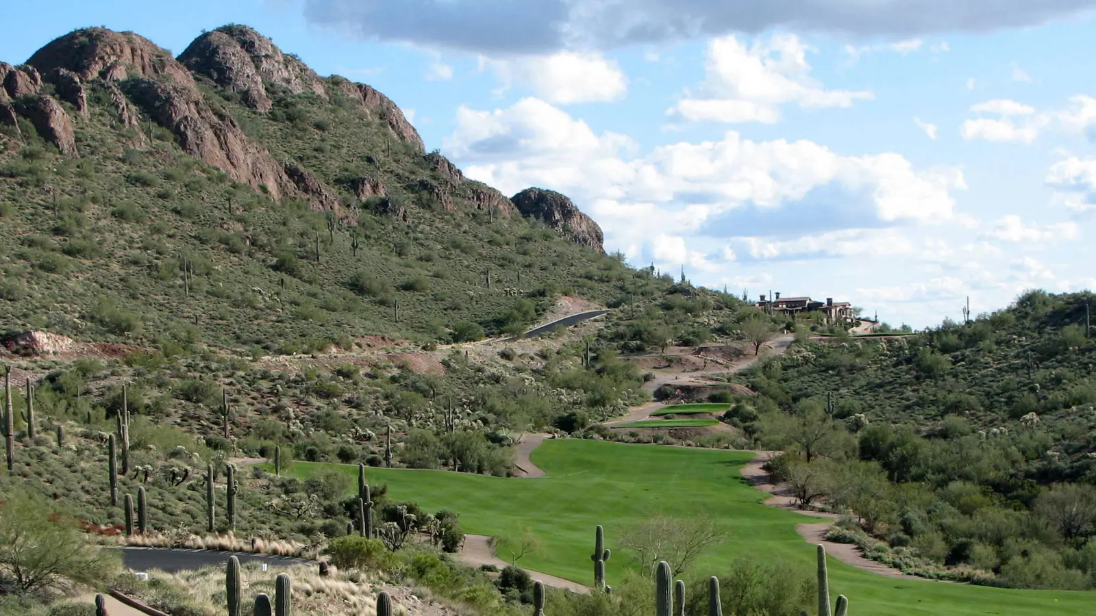Saguaro-lined fairway at Gold Canyon Golf Club below rocky Superstition foothills in Gold Canyon, Arizona