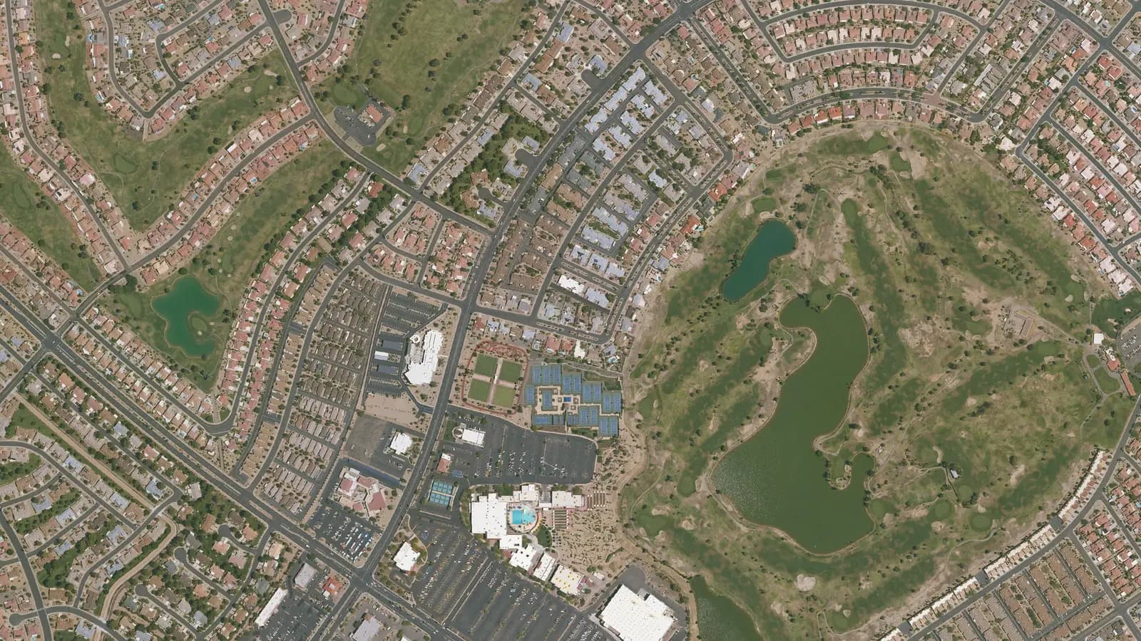 Aerial view of Sun City West, Arizona: golf course lake, recreation center and curving streets of homes
