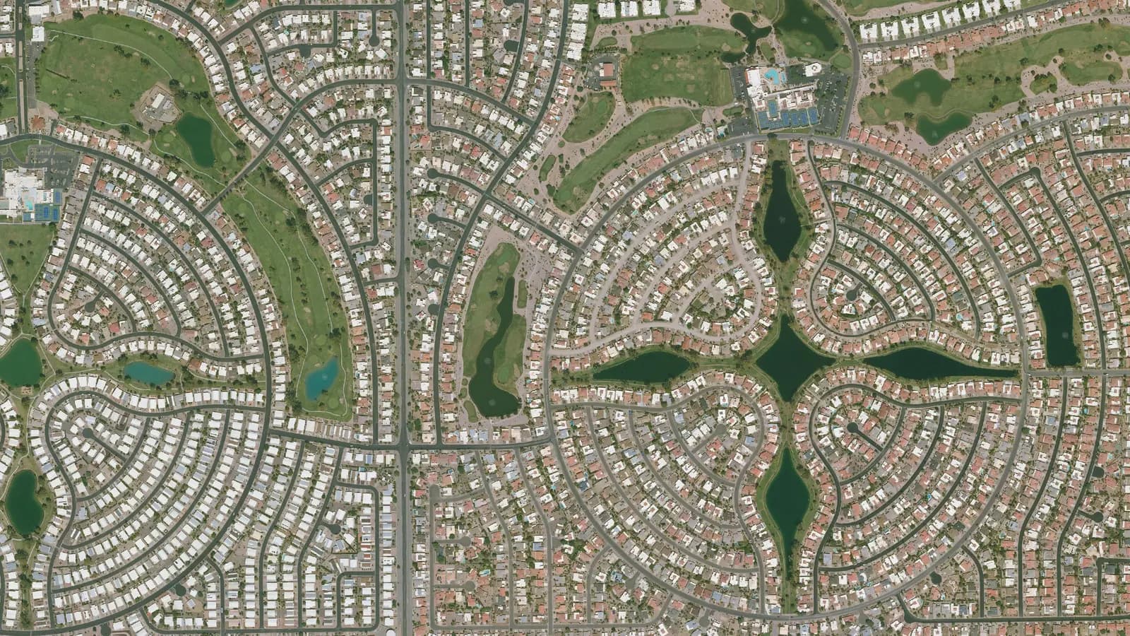 Aerial view of Sun Lakes, Arizona: a cross-shaped lake ringed by circular streets of homes and golf fairways