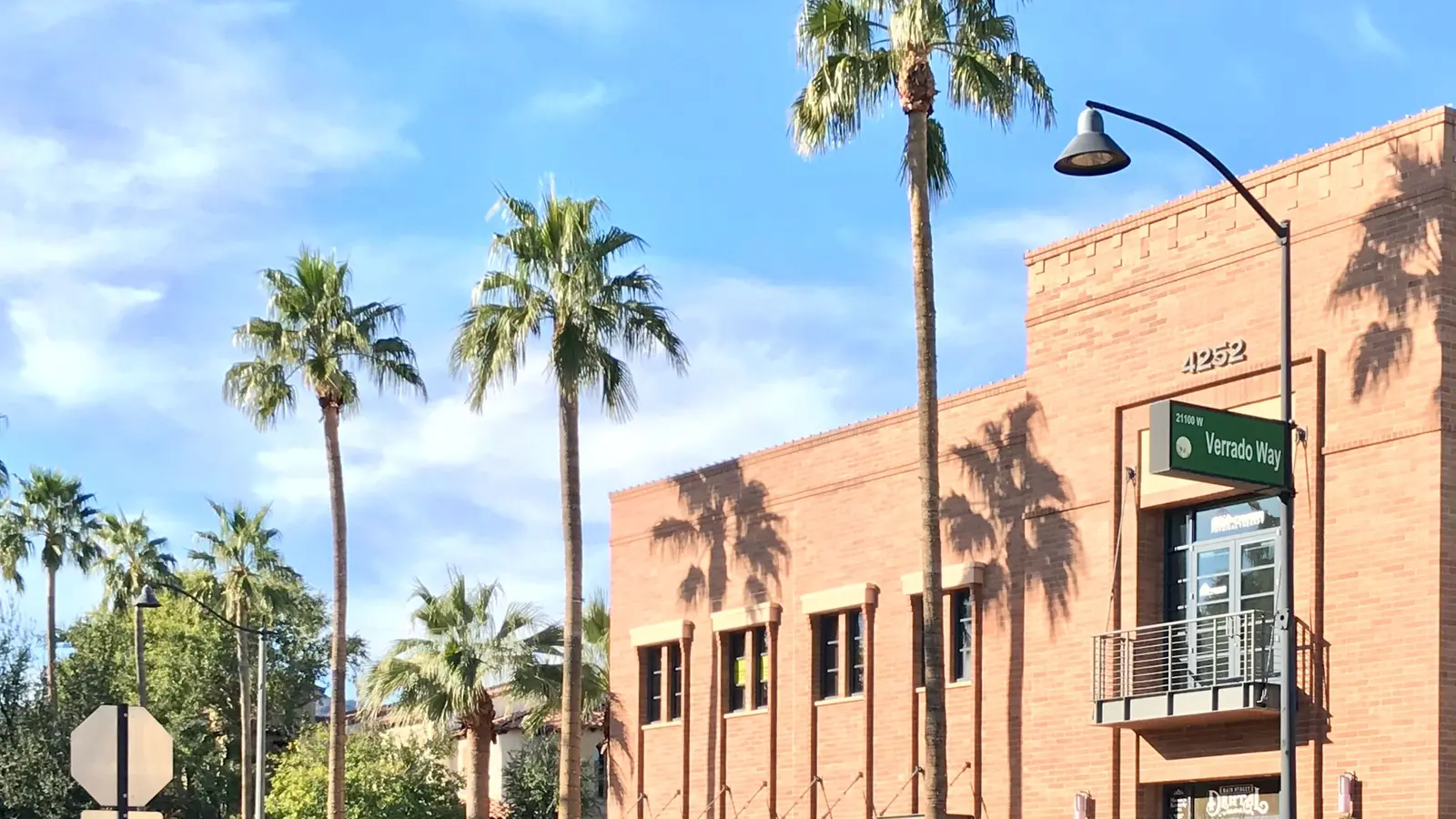 Palm-lined Verrado Way and a brick building in the Main Street district of Verrado, Buckeye, Arizona